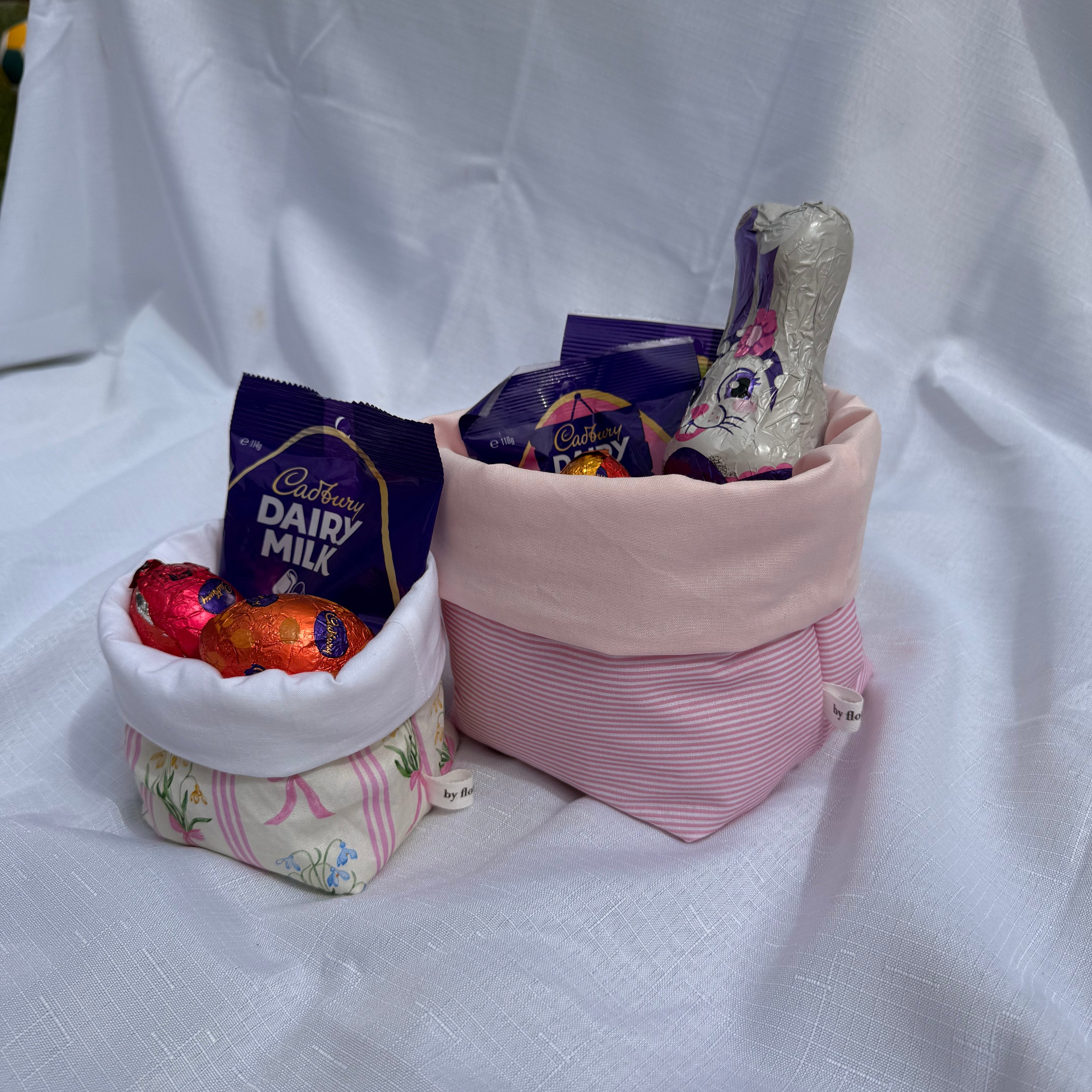 Bags of Cadbury Dairy Milk chocolate on a white fabric background