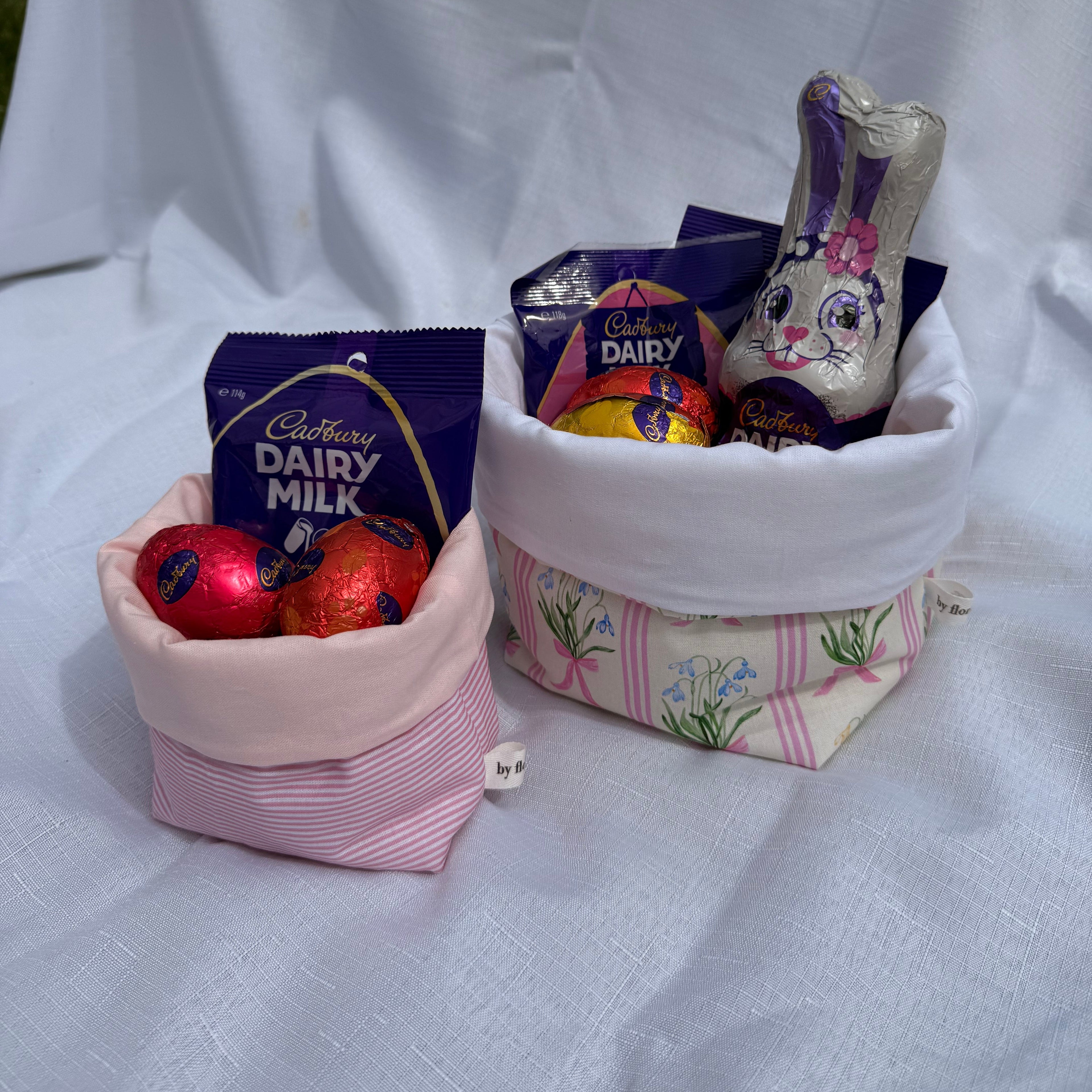 Small pink bag with Cadbury Dairy Milk chocolate bars on a white background
