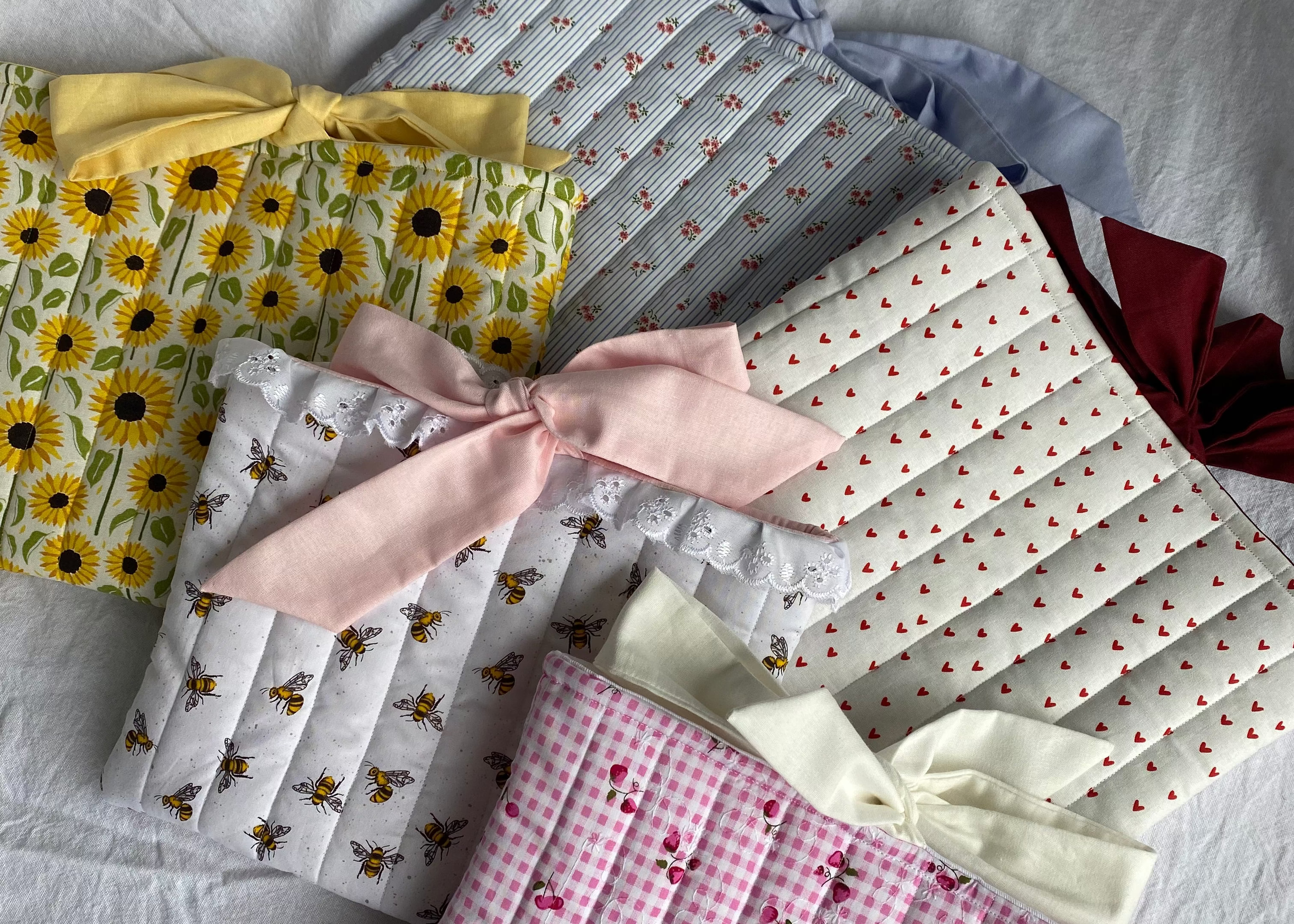 Collection of patterned fabric squares with ribbons on a textured surface